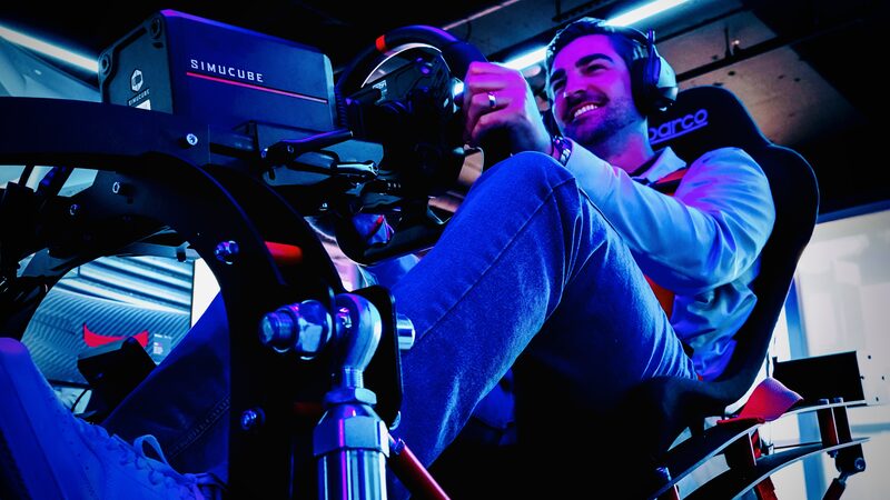 Driver gripping the direct-drive wheel mid-session